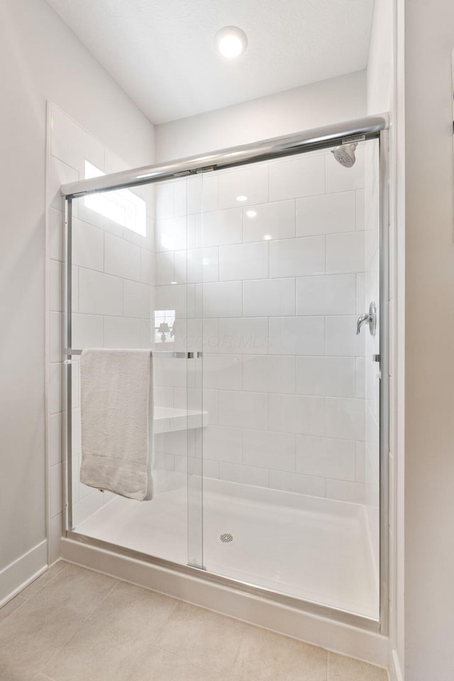 full bathroom featuring tile patterned flooring and a shower stall