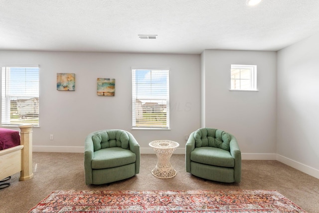living area with baseboards, visible vents, and a healthy amount of sunlight