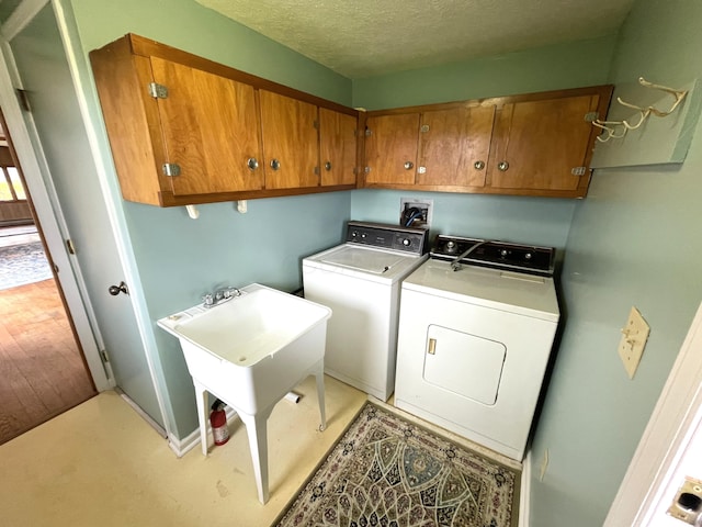 14963 Payne Rd, Marysville, OH 43040 - washroom with washer and clothes dryer, cabinet space, and a textured ceiling