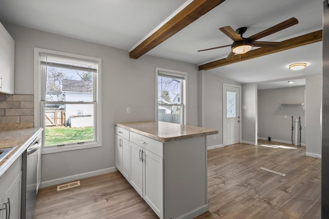 kitchen with a peninsula, dishwasher, a ceiling fan, beam ceiling, and tasteful backsplash