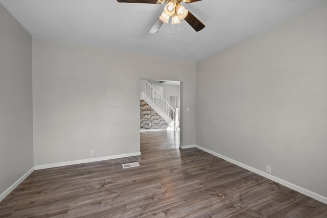 unfurnished room with stairway, wood finished floors, baseboards, visible vents, and ceiling fan