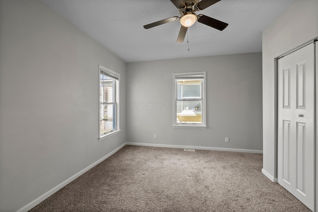 unfurnished bedroom with a ceiling fan, carpet, and baseboards