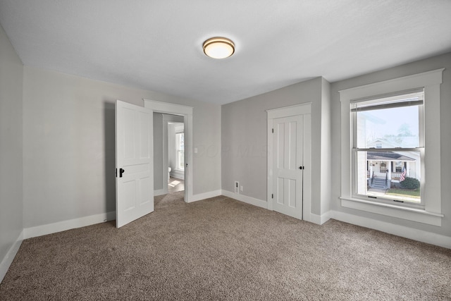 unfurnished bedroom with baseboards, a closet, and carpet