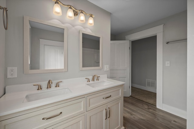 bathroom with baseboards, visible vents, a sink, and double vanity