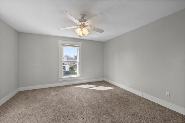unfurnished room featuring carpet flooring, baseboards, and ceiling fan