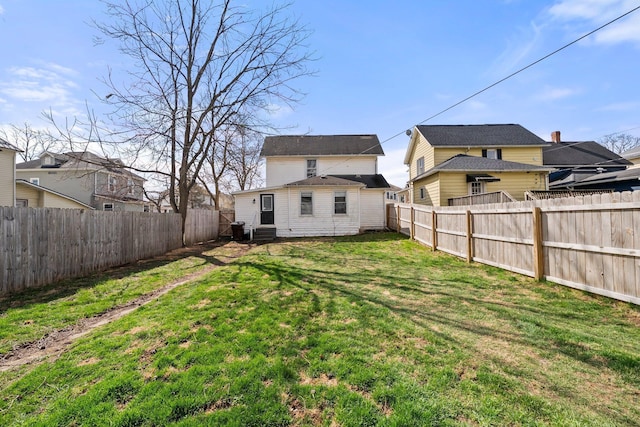 back of house featuring a fenced backyard and a yard