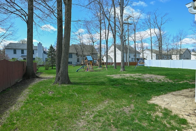 view of yard with a residential view, fence, and a playground