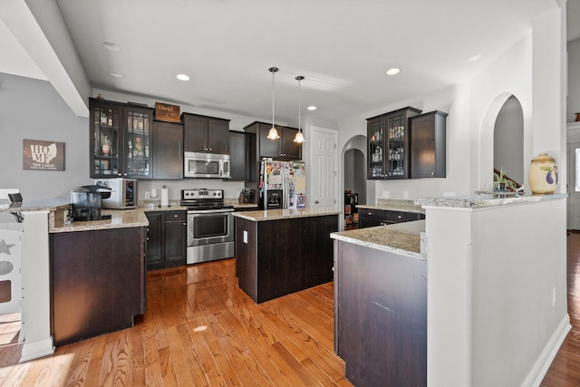 4600 Hirth Hill Rd E, Grove City, OH 43123 - kitchen featuring a peninsula, stainless steel appliances, light stone counters, and wood finished floors