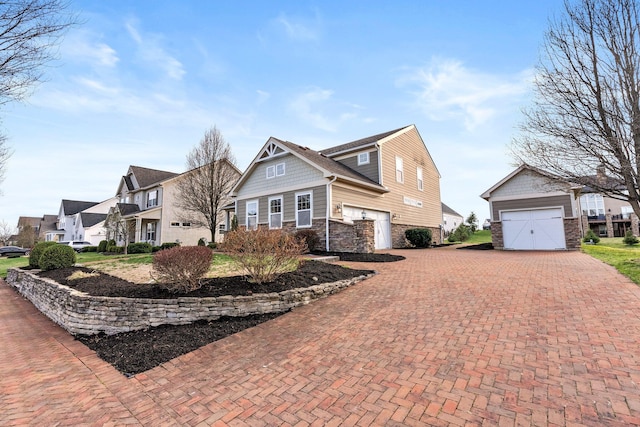 4600 Hirth Hill Rd E, Grove City, OH 43123 - view of front of home featuring an outdoor structure, stone siding, a residential view, decorative driveway, and a garage