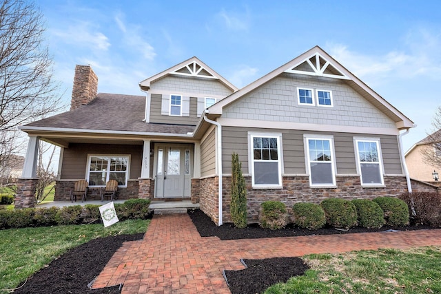 4600 Hirth Hill Rd E, Grove City, OH 43123 - craftsman inspired home featuring stone siding, a chimney, a front lawn, and covered porch