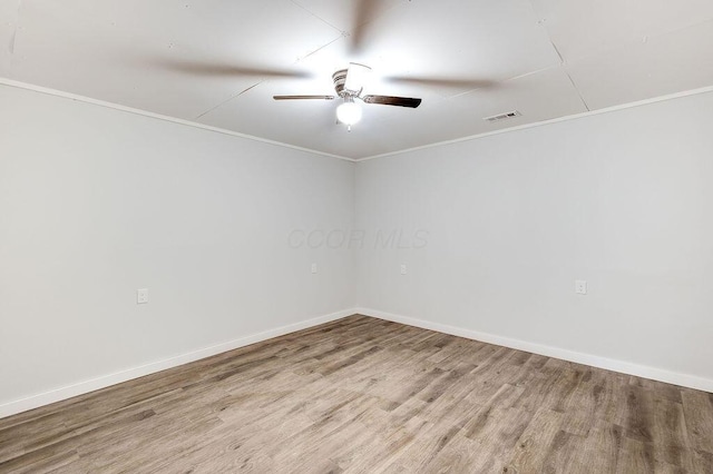 unfurnished room featuring visible vents, baseboards, ornamental molding, ceiling fan, and wood finished floors