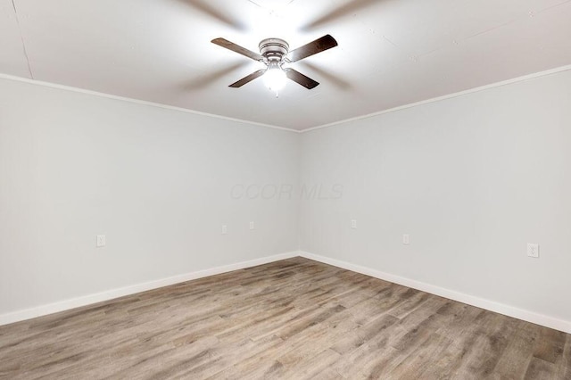 spare room featuring baseboards, wood finished floors, ornamental molding, and a ceiling fan