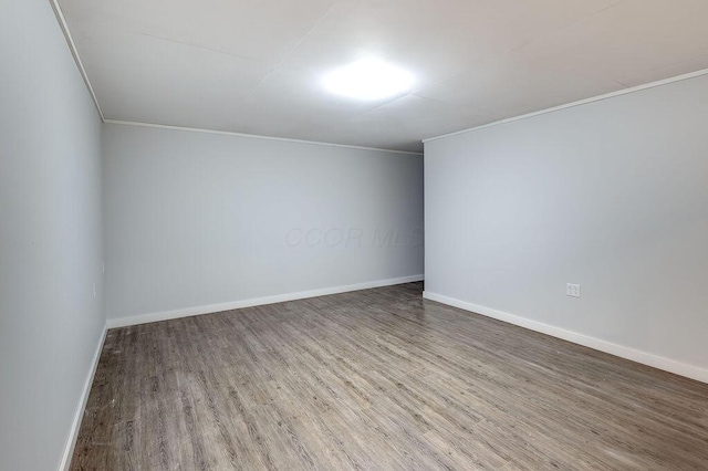 spare room featuring baseboards and wood finished floors