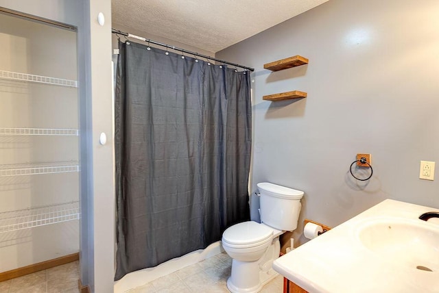 bathroom featuring tile patterned floors, toilet, curtained shower, a sink, and a textured ceiling
