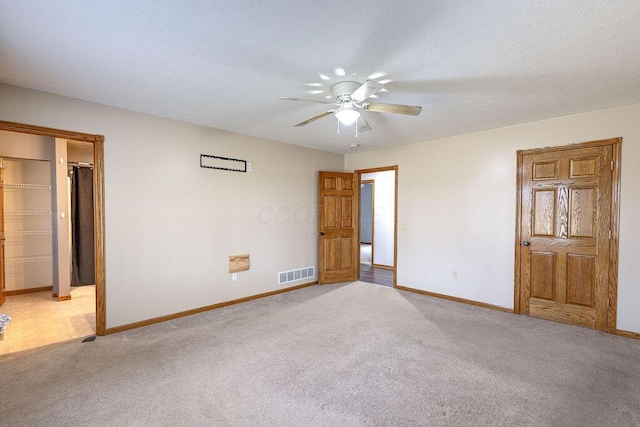 unfurnished bedroom with light carpet, baseboards, visible vents, and a textured ceiling