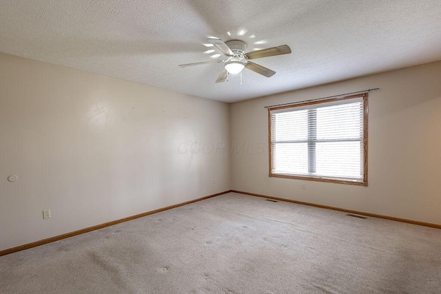 unfurnished room featuring a textured ceiling, visible vents, baseboards, ceiling fan, and light carpet