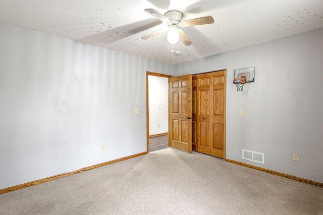 unfurnished bedroom featuring baseboards, visible vents, a ceiling fan, light carpet, and a closet