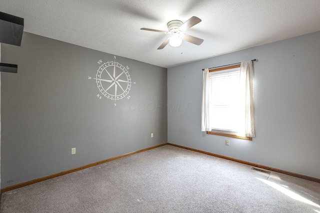 empty room featuring light carpet, baseboards, visible vents, and a ceiling fan