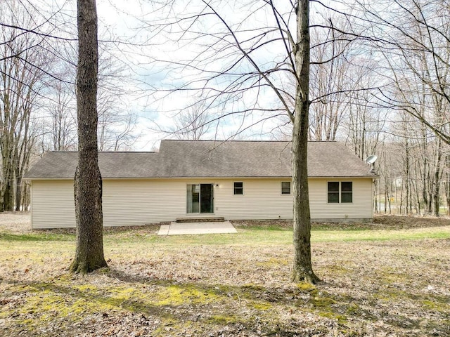 back of house featuring roof with shingles and a patio area