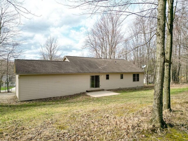 rear view of property featuring a patio and a yard