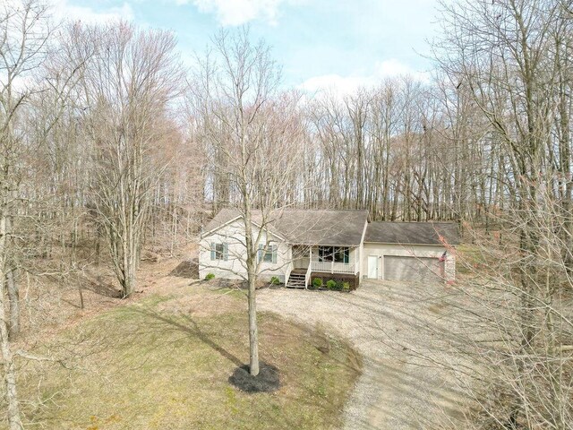 view of front facade featuring dirt driveway, a garage, and a front yard