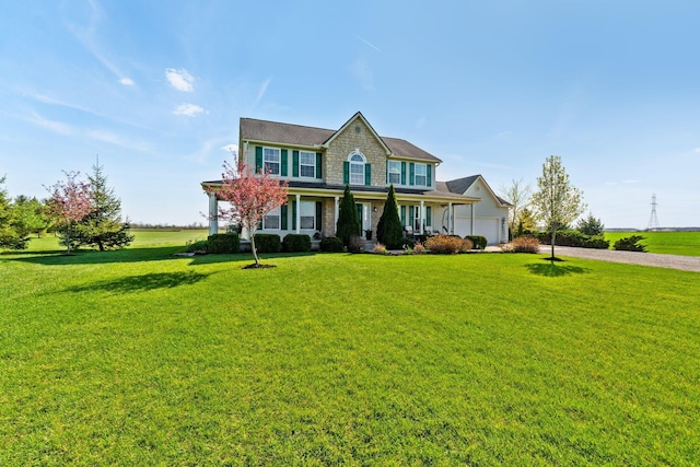 view of front of property with an attached garage, a porch, driveway, and a front yard