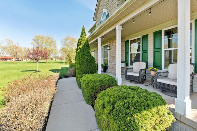 exterior space with a lawn, stone siding, and covered porch