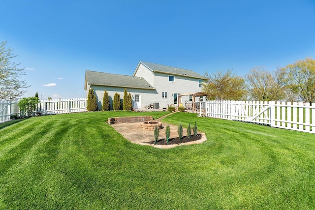 back of house featuring a fire pit, a lawn, a patio, and a fenced backyard
