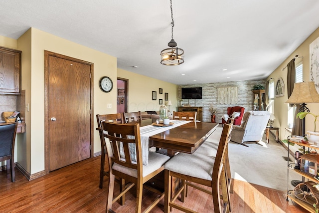 dining room with wood finished floors and a notable chandelier