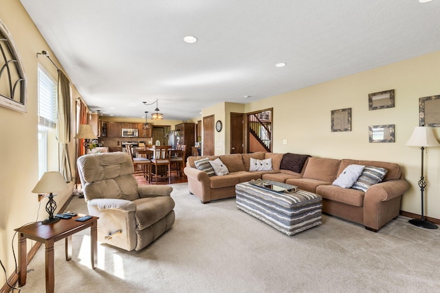 carpeted living area with recessed lighting and stairway
