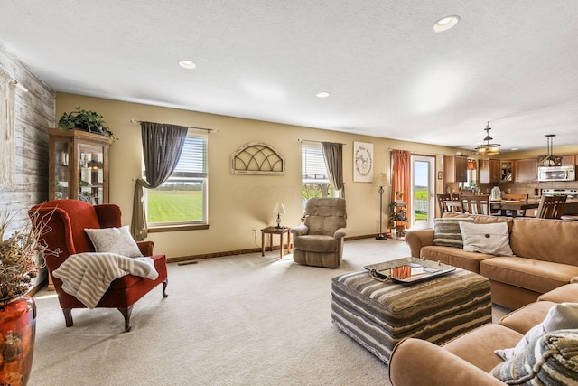 living area with light colored carpet, baseboards, a textured ceiling, and recessed lighting