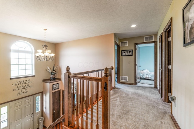 corridor with carpet flooring, an upstairs landing, and visible vents