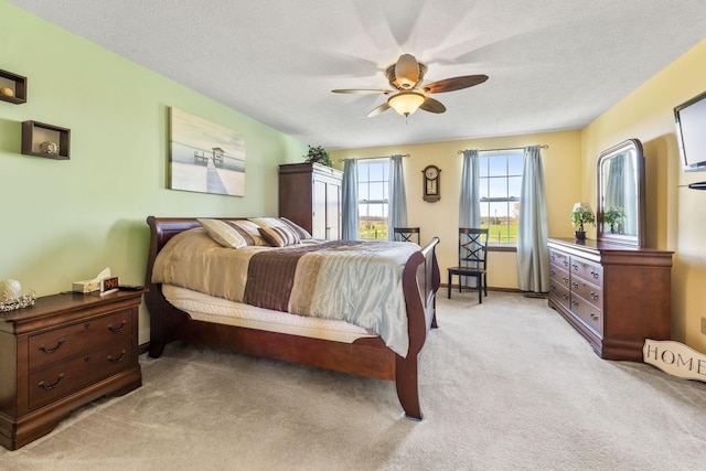 bedroom with light carpet, a textured ceiling, and ceiling fan