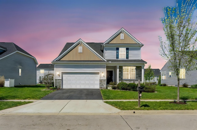 craftsman-style house featuring board and batten siding, a front yard, stone siding, and aphalt driveway