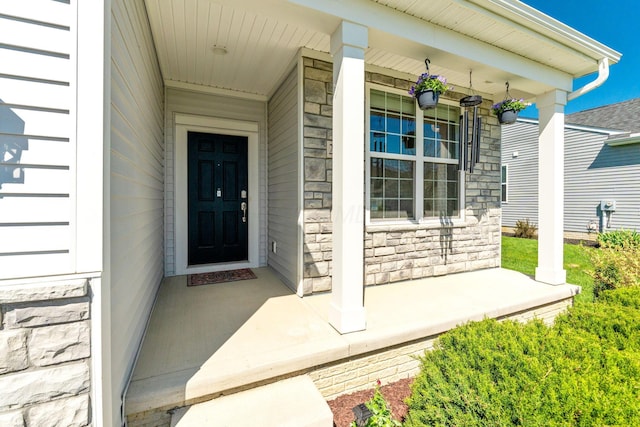 entrance to property featuring covered porch and stone siding