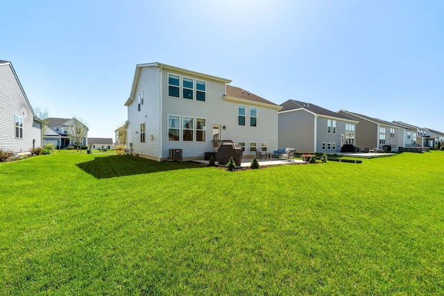rear view of property featuring a yard, a residential view, a patio area, and central air condition unit