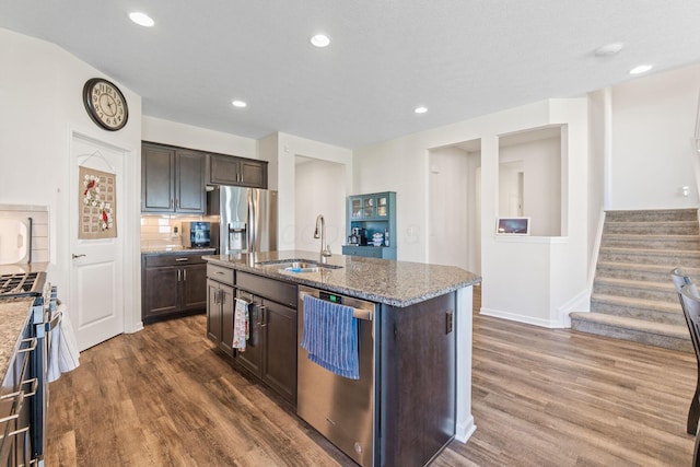 kitchen featuring a sink, appliances with stainless steel finishes, dark brown cabinetry, and stone counters