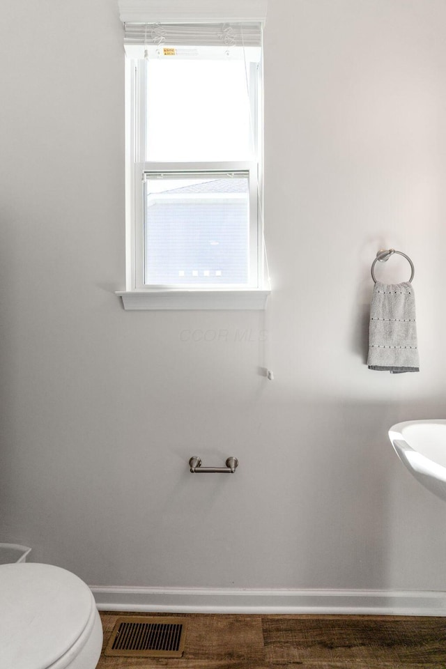 bathroom featuring baseboards, visible vents, and toilet