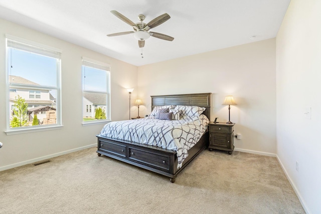 carpeted bedroom with baseboards, a ceiling fan, and visible vents