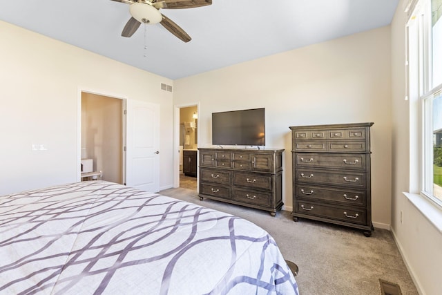 bedroom featuring baseboards, light colored carpet, connected bathroom, and visible vents