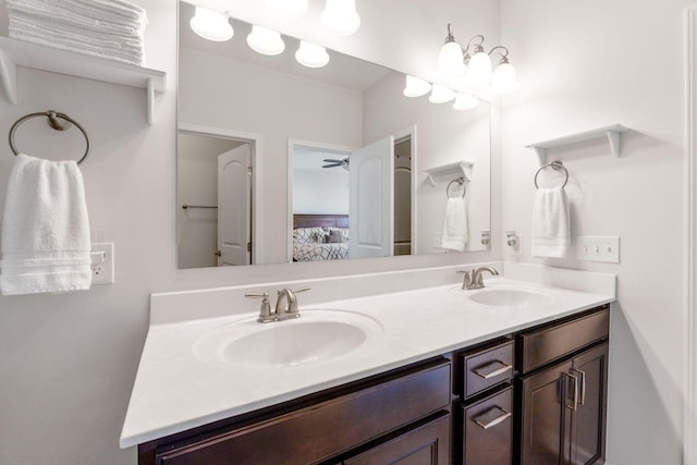 bathroom with a sink, double vanity, and connected bathroom