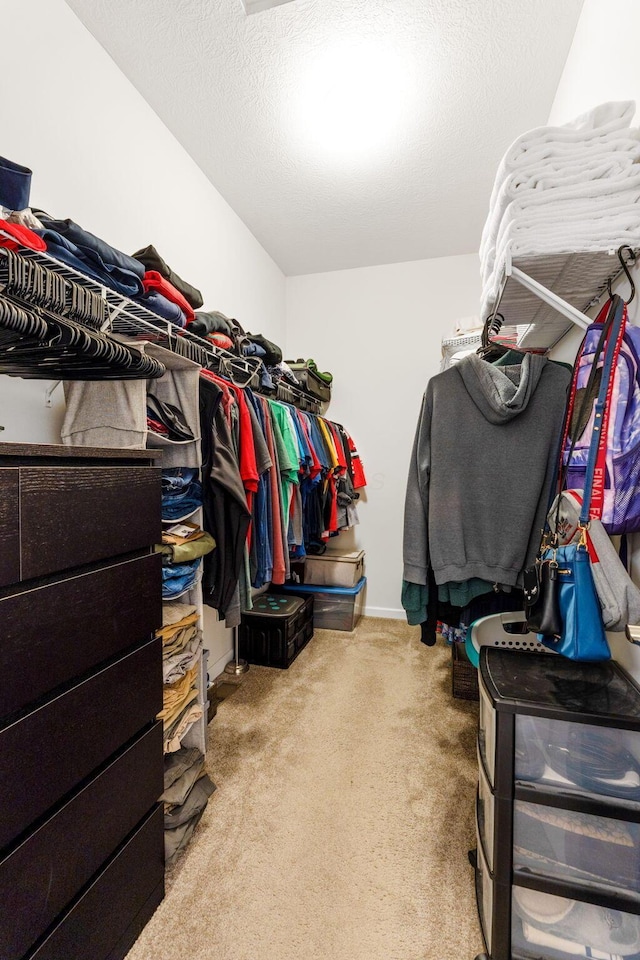 walk in closet featuring light colored carpet