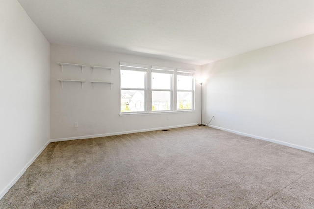 empty room with baseboards and carpet floors