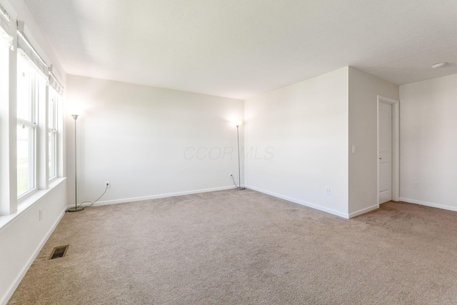 unfurnished room featuring visible vents, carpet flooring, and baseboards