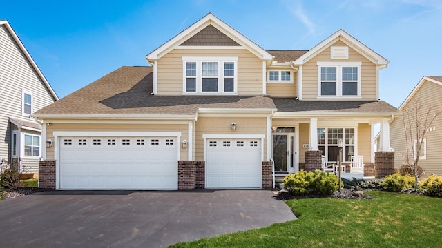 116 Coffeetree Ct, Pickerington, OH 43147 - view of front facade featuring covered porch, driveway, a front yard, a shingled roof, and brick siding