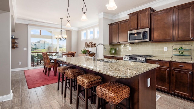 116 Coffeetree Ct, Pickerington, OH 43147 - kitchen with appliances with stainless steel finishes, a sink, backsplash, ornamental molding, and a kitchen island with sink