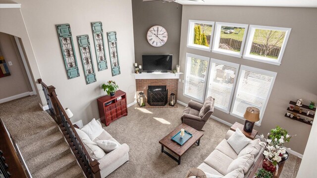 116 Coffeetree Ct, Pickerington, OH 43147 - living room featuring carpet floors, a brick fireplace, healthy amount of natural light, and a towering ceiling