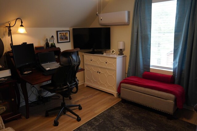 office featuring a wall mounted AC, wood finished floors, and vaulted ceiling