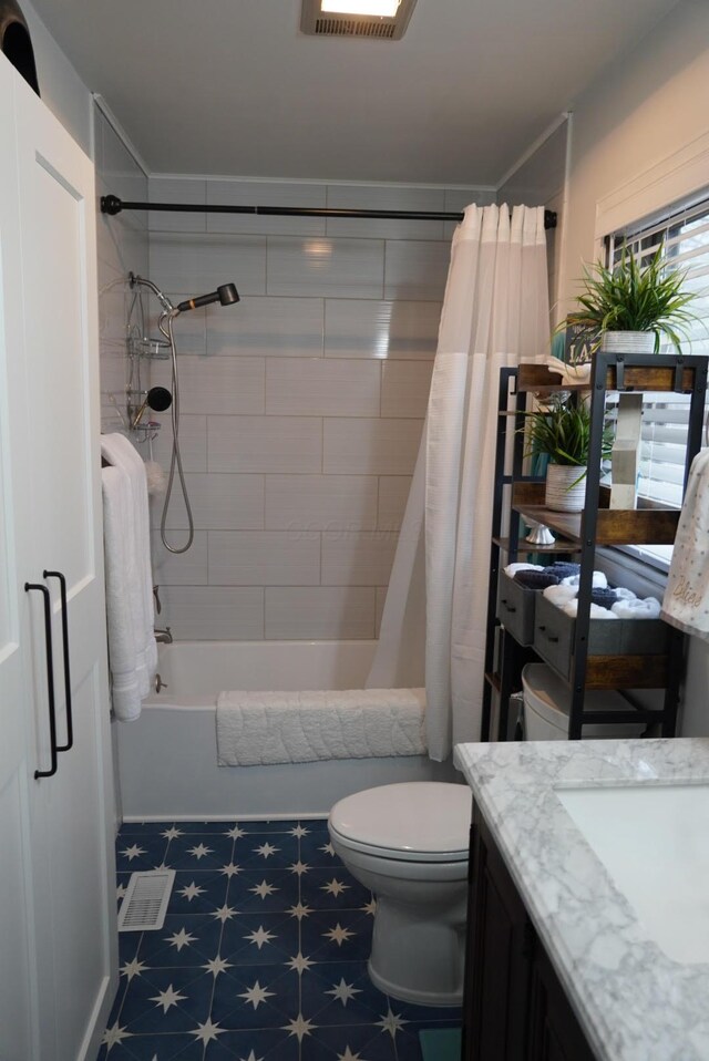 full bathroom with visible vents, toilet, tile patterned floors, vanity, and shower / tub combo