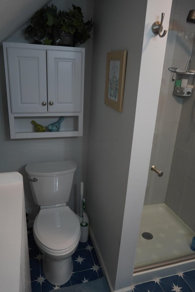 full bathroom featuring toilet, baseboards, and a shower stall